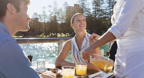 Couple enjoying food and drinks at Hugos Manly at Manly Wharf