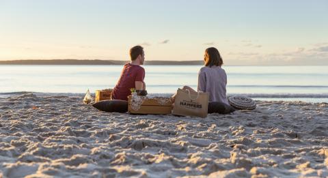 Paar genießt ein Picknick gepackt von Hyams Beach Hampers am Blenheim Beach, Jervis Bay